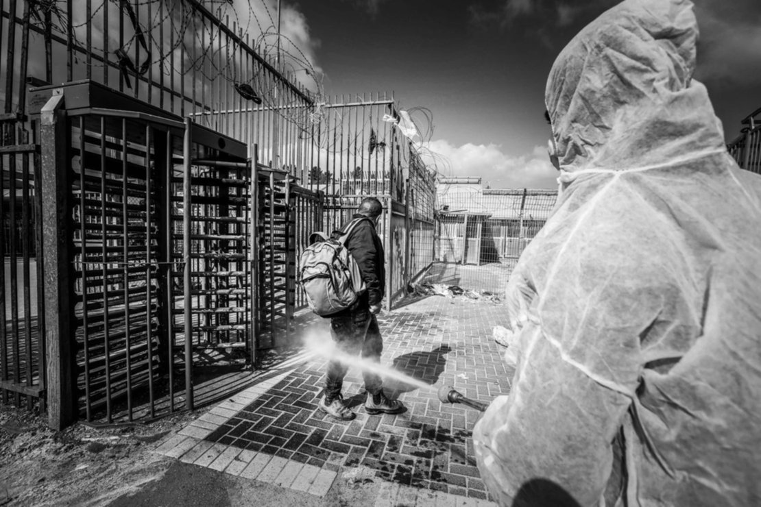 Un empleado del ministerio de salud palestino desinfecta a un trabajador que regresa de Israel por la frontera. Un empleado del ministerio de salud palestino desinfecta a un trabajador que regresa de Israel por la frontera.
