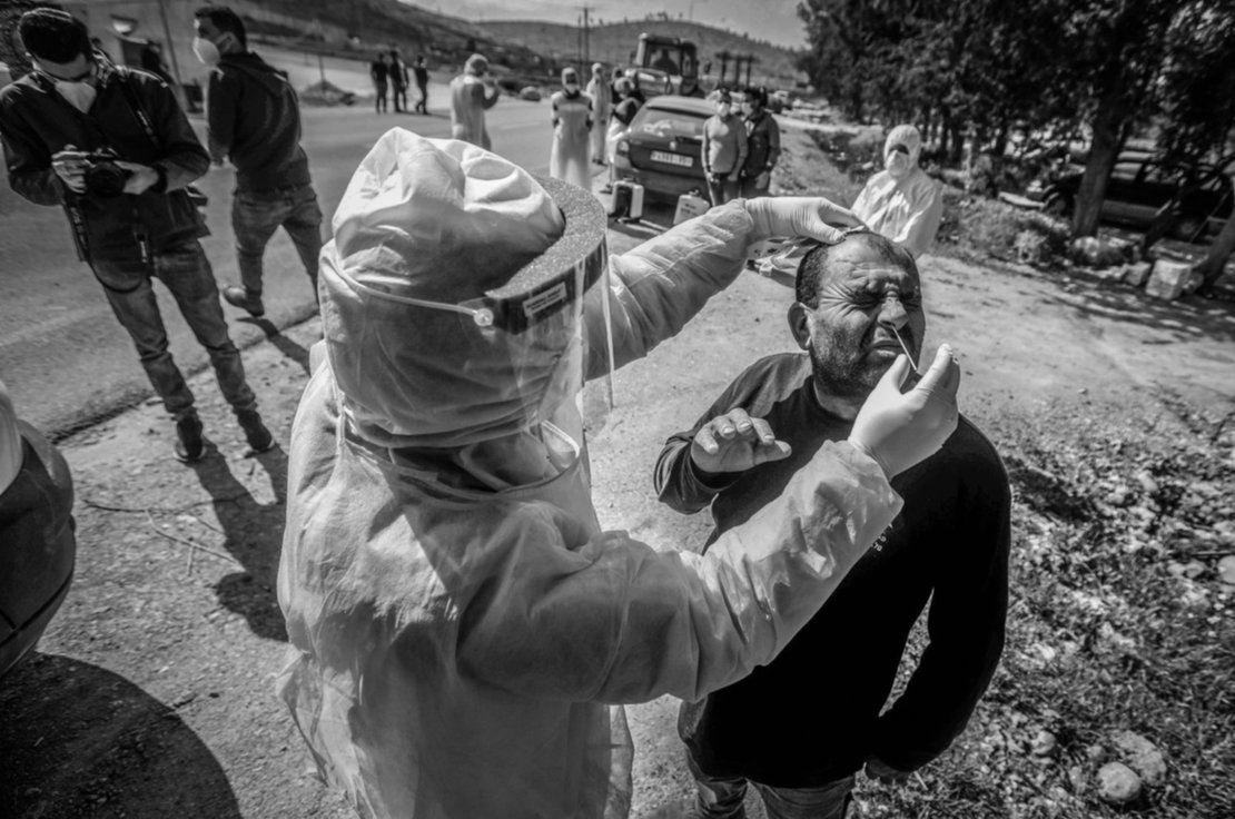 Un trabajador del ministerio de salud palestino recoge una muestra de saliva de un ciudadano. Un trabajador del ministerio de salud palestino recoge una muestra de saliva de un ciudadano.