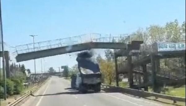 Un camión con la batea levantada chocó contra un puente y lo derribó